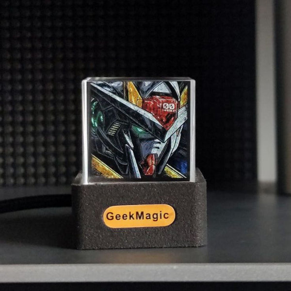 The 3D Icon Desk Light Decor by The Projection Room features a small, square display with a vibrant robot head illustration in angular shapes. It sits on a black GeekMagic stand against a dark shelf, offering customizable content for style and versatility.