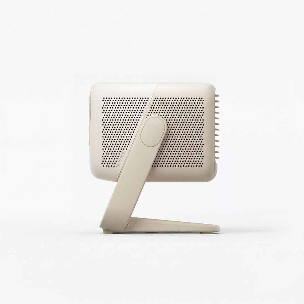 The JMGO N1S Nano by JMGO is a beige, rectangular projector with a perforated surface and angled stand—perfect for enjoying Google TV on a big screen.