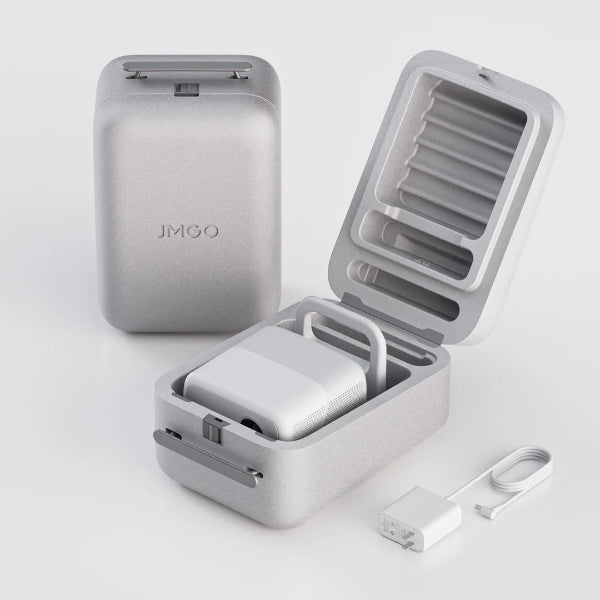 The JMGO N1 Full HD Triple Laser Projector is stored in a gray, textured case embossed with JMGO. The open lid reveals the device inside, with a compact power adapter and cable beside it on a white surface.