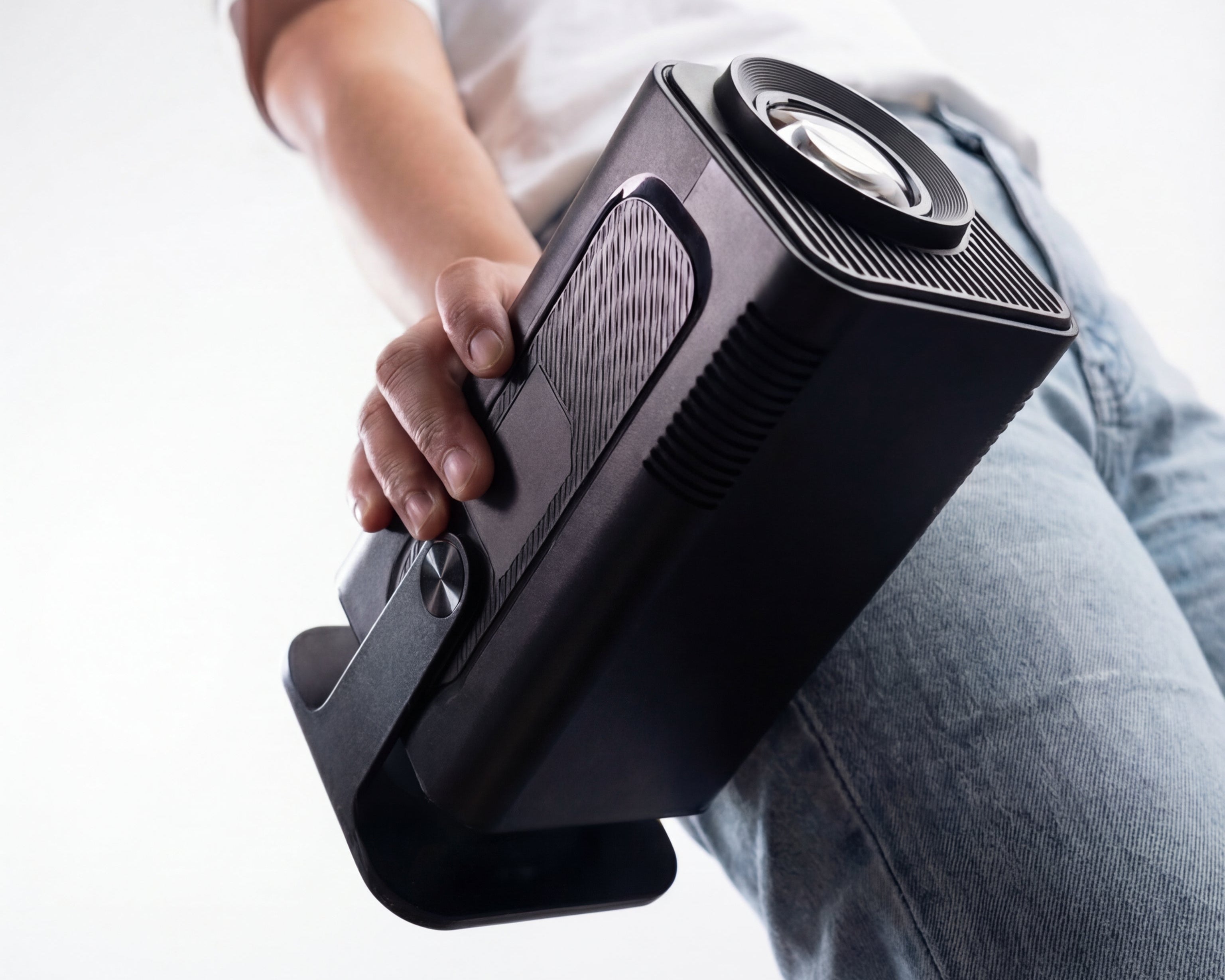 Person holding a black suitcase against a white background